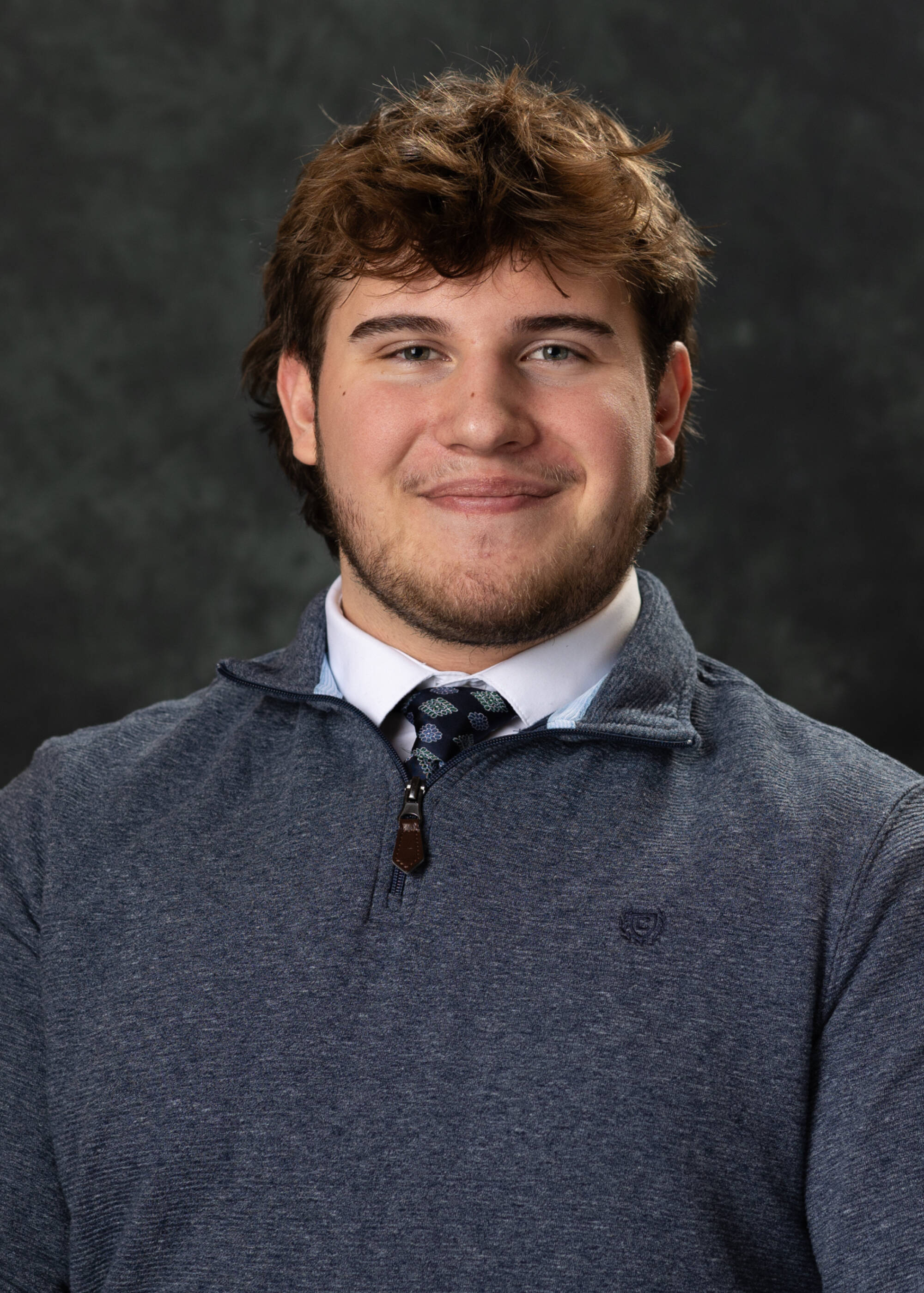 Joshua Smith smiling in a gray quarter zip